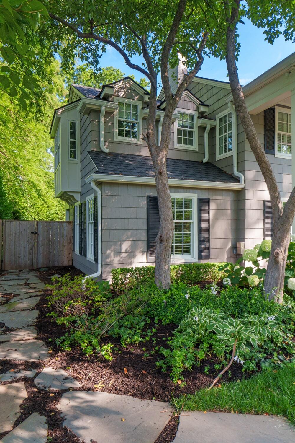 Side yard displaying cantilever with corbels below, hanging above the landscaped garden path.