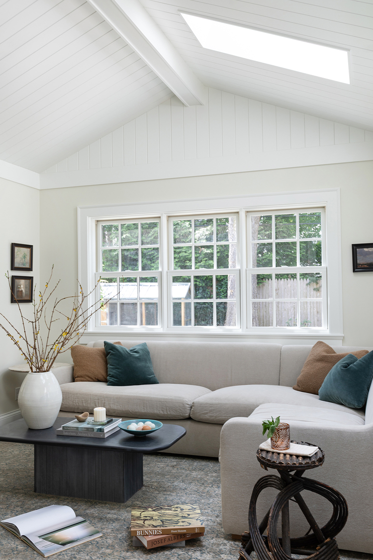 Vaulted ceiling with skylight and v-groove paneling hangs above this relaxing living space.