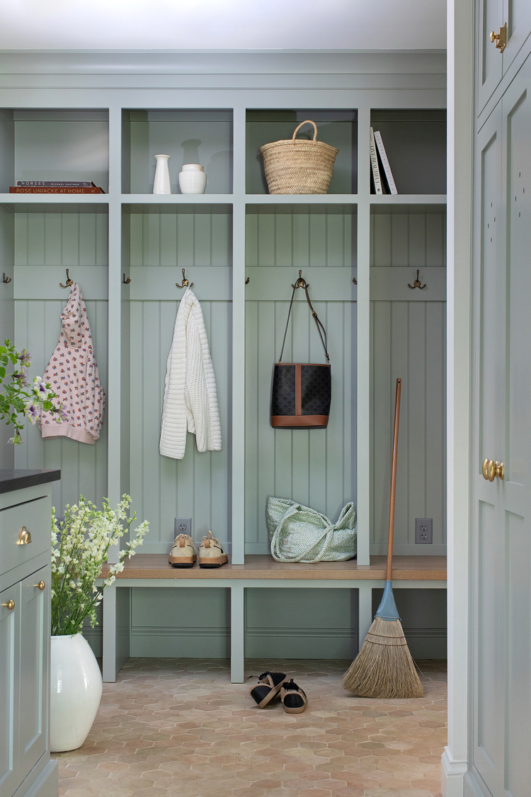 Custom mudroom with inset locker cabinets in a misty blue-green with brass and oak finishes.