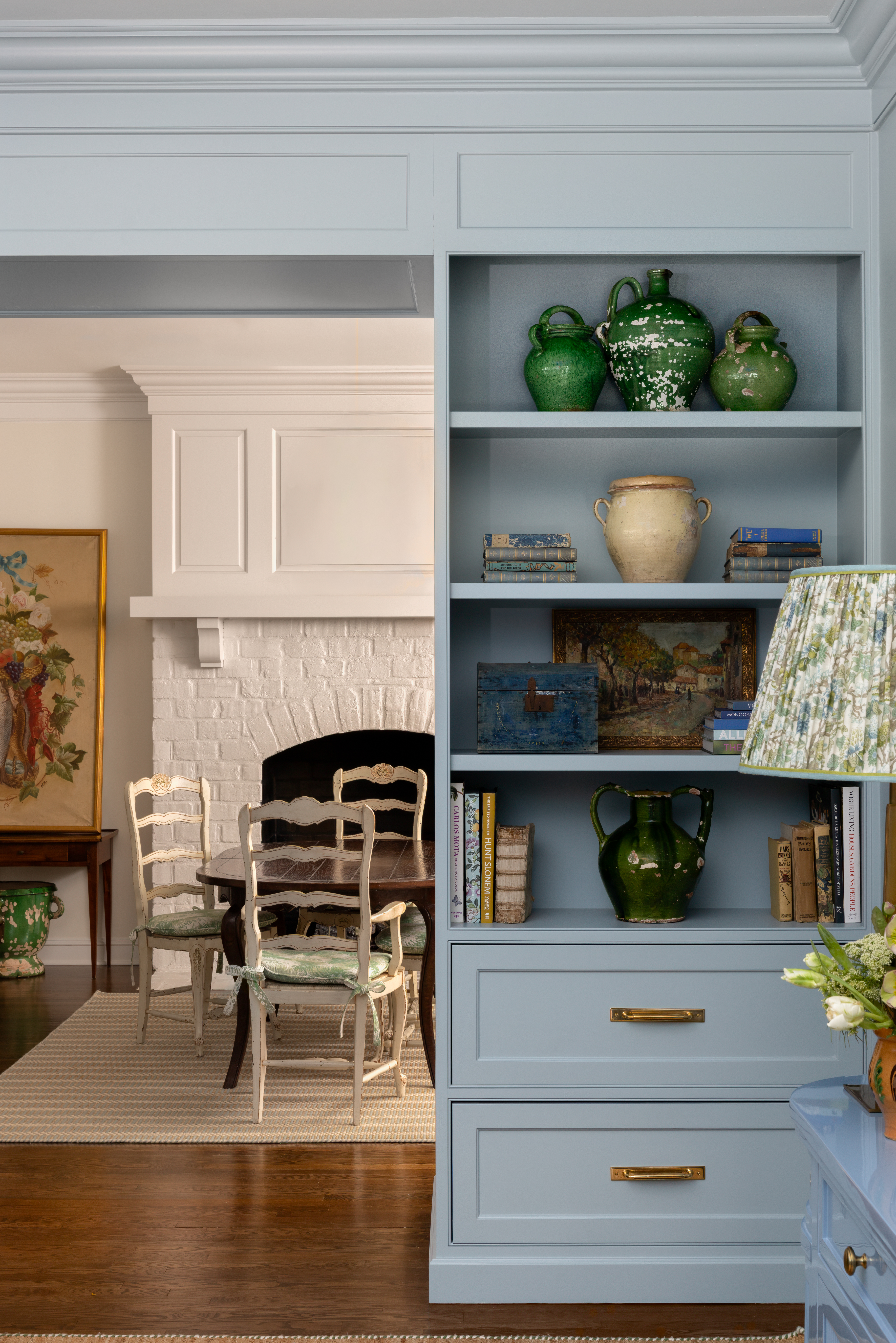 Interior space with blue built in shelving leading into kitchen 