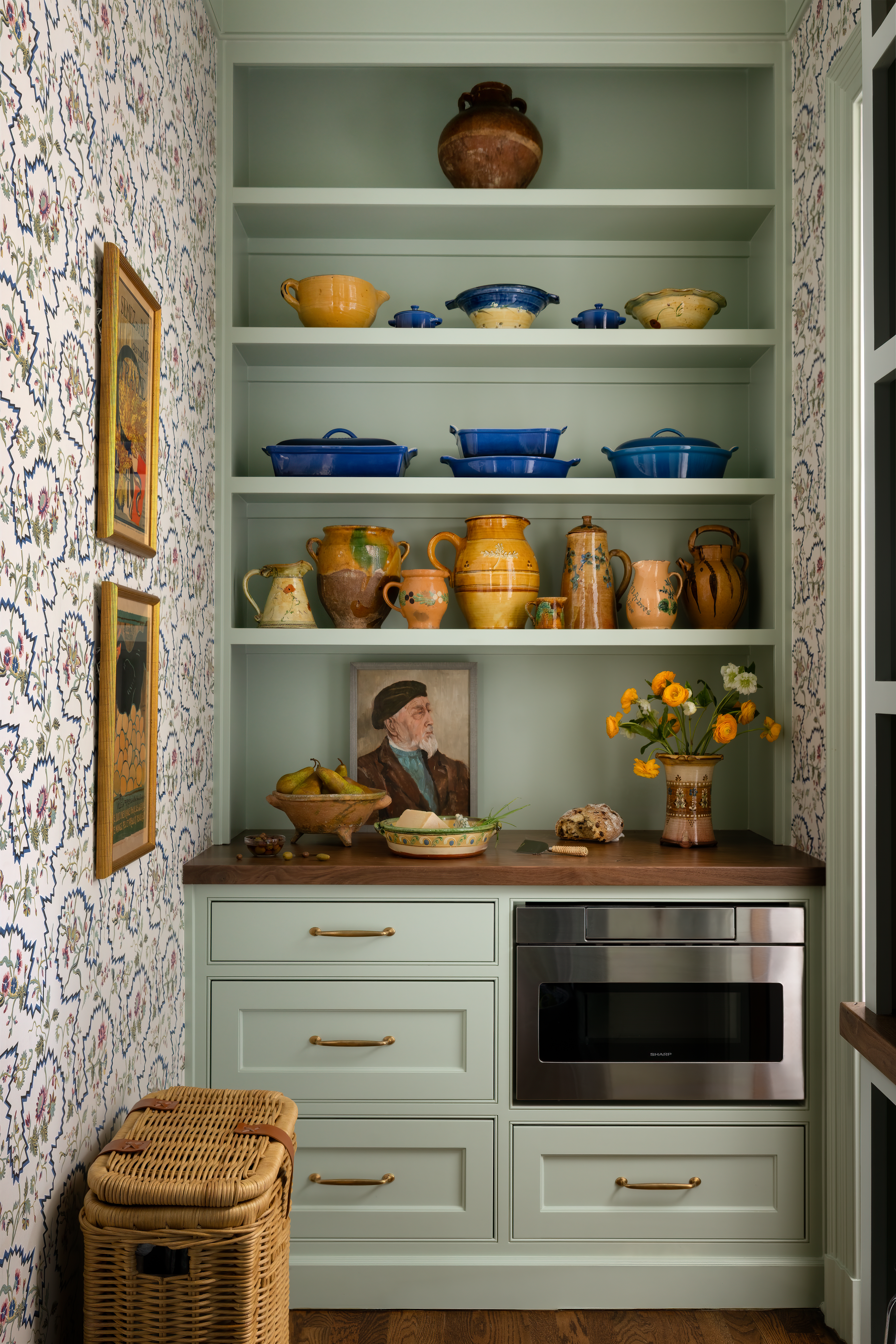 Light green butler's pantry with colorful ceramic dishware 